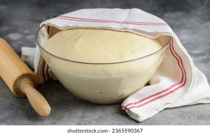 Yeast dough in a glass bowl.  Cooking process. Selective focus