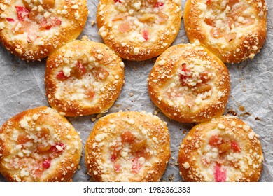 Yeast sweet rolls with rhubarb and crumble on baking paper top view