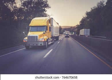 Yellow 18 wheeler truck on highway
