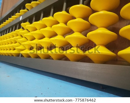 Yellow abacus lay on a table in the classroom.