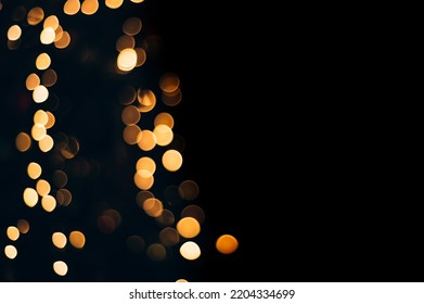 Yellow abstract bokeh made from Christmas lights on black isolated background. Holiday concept, blur bokeh, overlay for your images. - Shutterstock ID 2204334699
