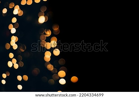 Yellow abstract bokeh made from Christmas lights on black isolated background. Holiday concept, blur bokeh, overlay for your images.