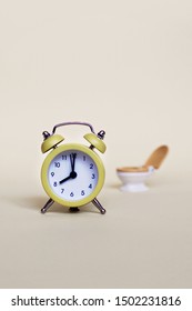 Yellow Alarm Clock And White Toilette Bowl Over Light Background, Healthcare And Wasting Time Concept 