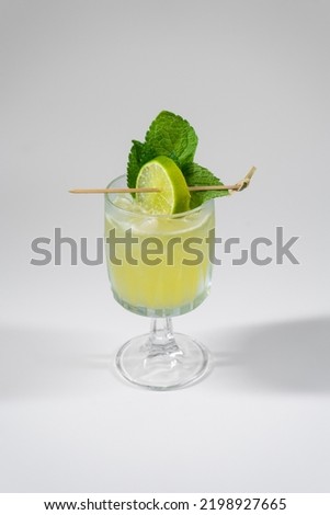 yellow alcohol cocktail with lime, mint, ginger, honey, isolated on white