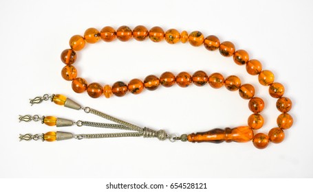 Yellow amber prayer beads (rosary) on white background