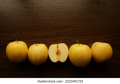 yellow apple and one half  of golden apple. Top view. wooden table surface.  - Shutterstock ID 2215491723