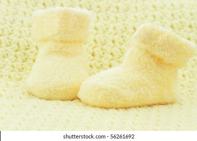 Yellow Baby Booties And Blanket With Room For Text.