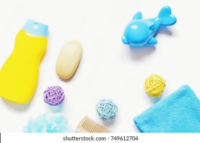 Yellow Baby Shampoo Bottle, Soap Bar, Colorful Rattan Balls, Toy Dolphin, Sponge And Blue Terry Towel. Flat Lay Bath Products. Mockup, Copy Space