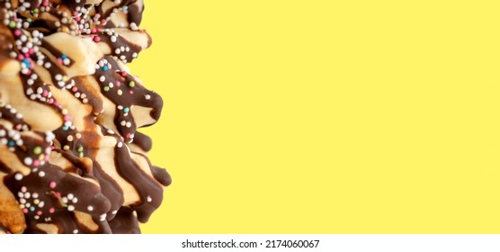 yellow background with part of homemade chocolate cake with sprinkles    High-quality photo for  cards. Space for text - Shutterstock ID 2174060067