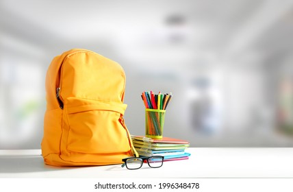 Yellow backpack on table empty copy space. School supplies. Education objects. - Shutterstock ID 1996348478