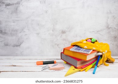 Yellow backpack with white polka dots with different colorful stationery on table. gray concrete background. Back to school. Banner design - Powered by Shutterstock