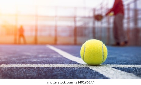 Yellow Ball On Floor Behind Paddle Net In Blue Court Outdoors. Man Who Playing Padel Tennis. Caucasian Player Sportsman Hitting Balls. Racquet Sport Game Concept.