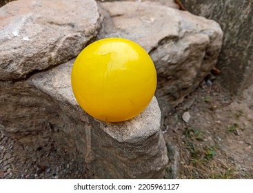 Yellow Ball On A Weathered Rock.