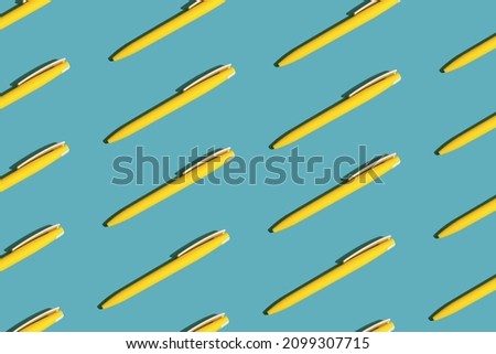 Yellow ballpoint pens on a blue background. Seamless repeating pattern.