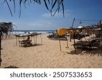 A yellow beach with rustic sunbeds in Hikkaduwa, Sri Lanka, on a sunny day in December 