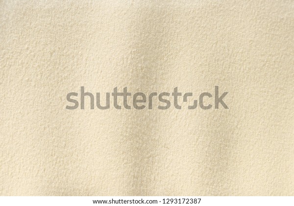 Yellow - beige chamois cloth background.\
Surface of fabric texture in cream\
color.