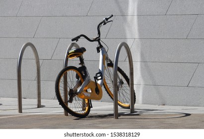 Yellow Bicycle On A Bike Rack. The Bicycle Has A Bent Wheel. Sydney