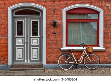 Yellow Bicycle Parked In Front Of Red Old House In Denmark