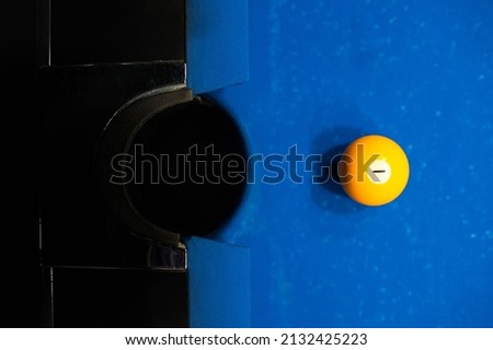 yellow billiard ball floor number one is lying on the table with a blurred background