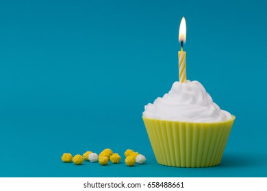 Yellow Birthday Cupcake With Candle On Blue Background