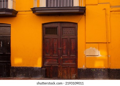 Yellow And Black Colonial Facade With A Large Dark Wood Door From The Center Of Town