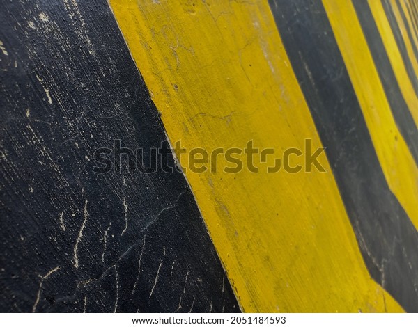Yellow and black color stripes\
of road dividers or traffic signs that are often found on the\
streets