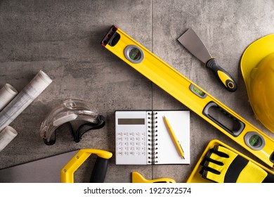 Yellow and black contractor equipment on gray tiles.