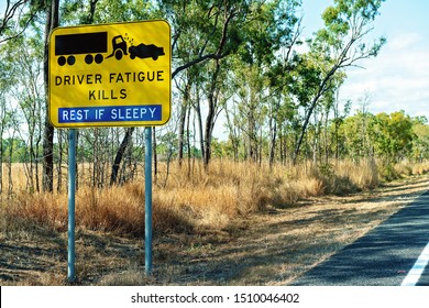 A yellow and black driver fatigue causes crashes alert sign on highway