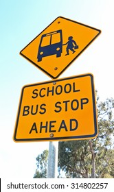 Yellow And Black School Bus Stop Ahead Sign And Blue Sky