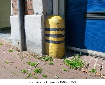 yellow black striped stone near a blue garage door