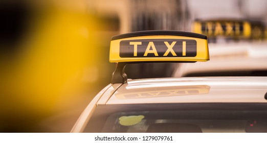 Yellow And Black Taxi Poster On Top Of Car In Berlin City Germany