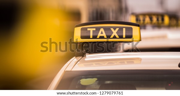 Yellow and black taxi poster on top of car in\
berlin city germany
