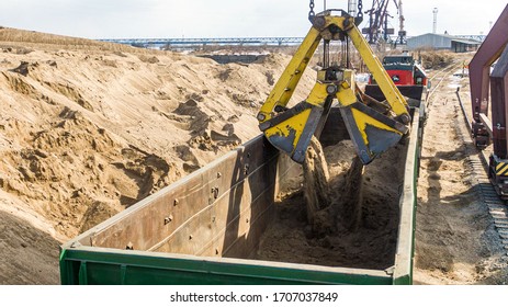 A Yellow And Black Truck Sitting On Top Of A Dirt Field