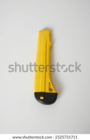  Yellow and black utility knife on a white background                              