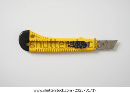  Yellow and black utility knife on a white background                              