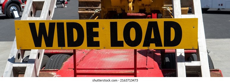 Yellow And Black Wide Load Sign On The Back Of A Trailer