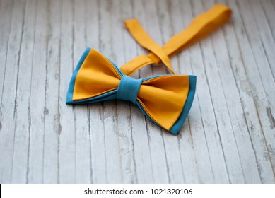 Yellow, blue bow tie on a wooden background. Accessory for formal dress. Symbol of elegance and fashion for men. Men's casual. Men's and women's accessories. Men's and women's bowtie. - Powered by Shutterstock