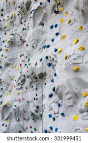 Yellow Blue And Green Hand And Foot Holds On A Rock Climbing Wall