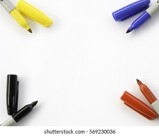 Yellow blue red and black sharpie markers on all four corners of a large blank white background - Powered by Shutterstock