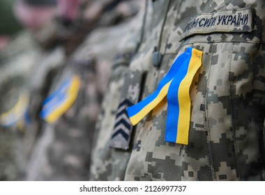 Yellow and blue ribbon (colors of Ukraine) attached to the chest of the Ukrainian Army (inscription in Ukrainian "Armed Forces of Ukraine") - Shutterstock ID 2126997737
