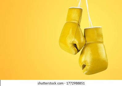 Yellow boxing glove on yellow colored background. - Powered by Shutterstock