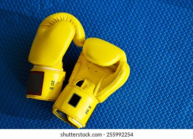 yellow boxing gloves on blue mat - Powered by Shutterstock