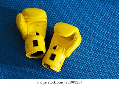 Yellow Boxing Gloves On Blue Mat