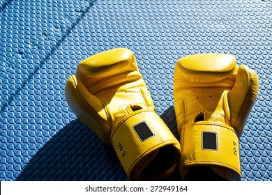 Yellow Boxing Gloves On Blue Exercising Mat