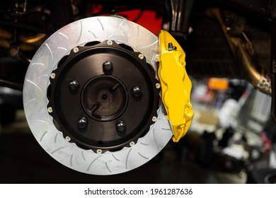 yellow brake caliper and disc isolated on car