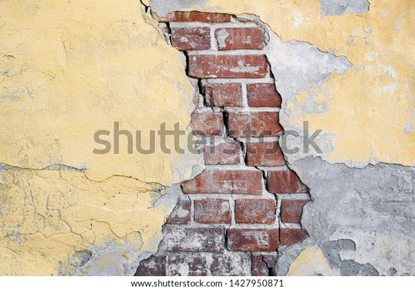 Yellow Brick Wall Of House\
Is Divided By Huge Crack. The Collapse Of Wall. Seismic Activity,\
Earthquake.