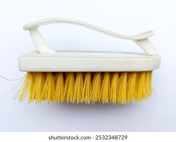 Yellow bristled brush with plastic handle used to clean stains on clothes on an isolated white background - Powered by Shutterstock