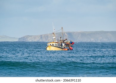 Yellow British fishing boat trawler alone in the English channel islands waters after leaving EU with no French fisherman boats or nets in view. Territorial waters under England's control.
