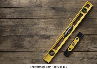 Yellow Building Level On Old Wood Table