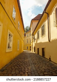 Yellow Buildings In Prague Alley, The Old City, Praha Narrow Street With Cobblestones, Alleyway Medieval Street, Jewish Quarter, Czech Republic. Selective Focus.